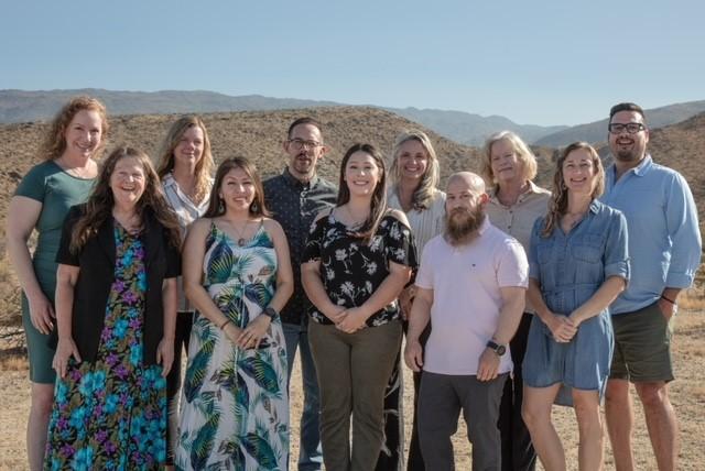ABF staff with desert and mountains in background on a sunny day.